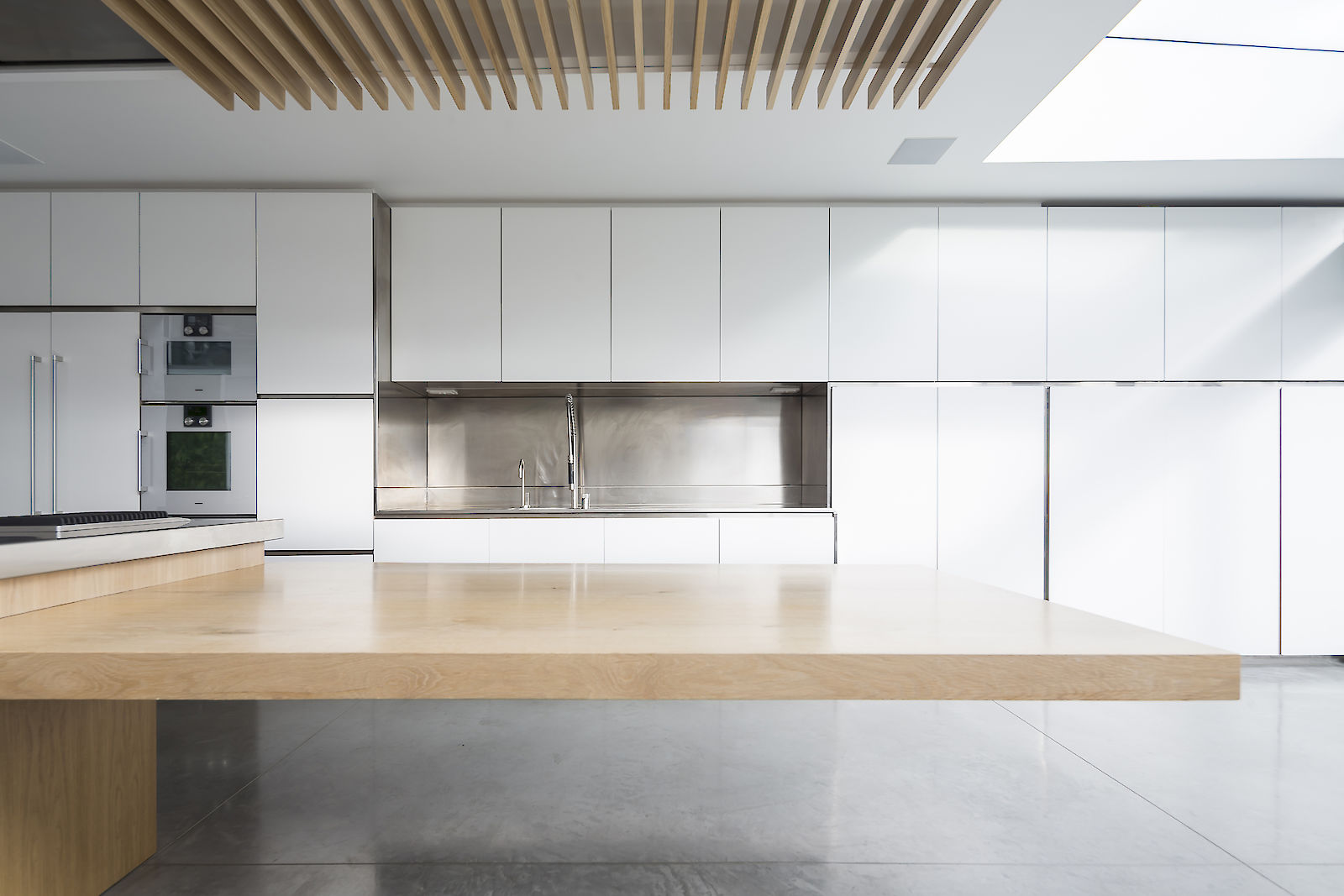 GC House in Fulham by inaki leite design. Bespoke design for kitchen with oak cantilever dining and mate white cabinets