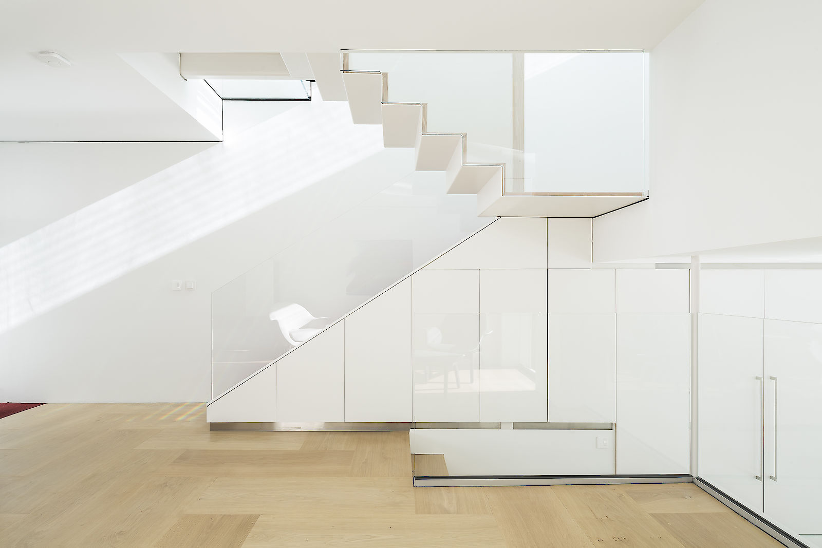 GC House in Fulham by inaki leite design. Bright elevation of ground floor red stairs, folded steps with cascade skylight two floors on top