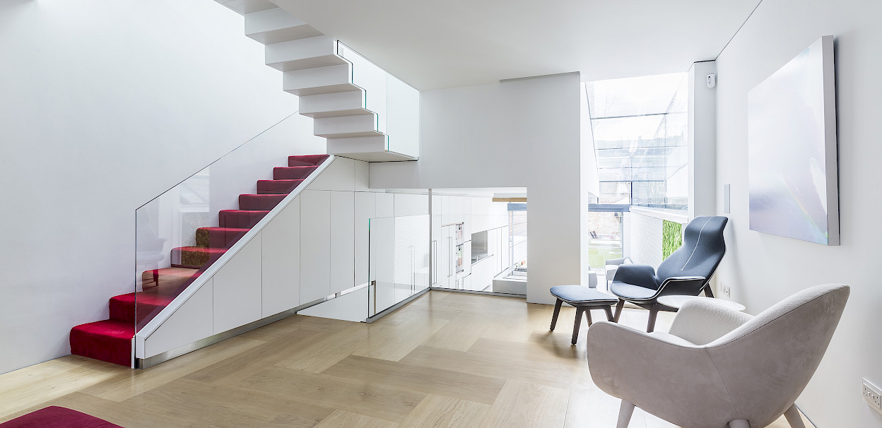 GC House in Fulham by inaki leite design. Reception room with red stairs, folded steps with cascade skylight two floors on top